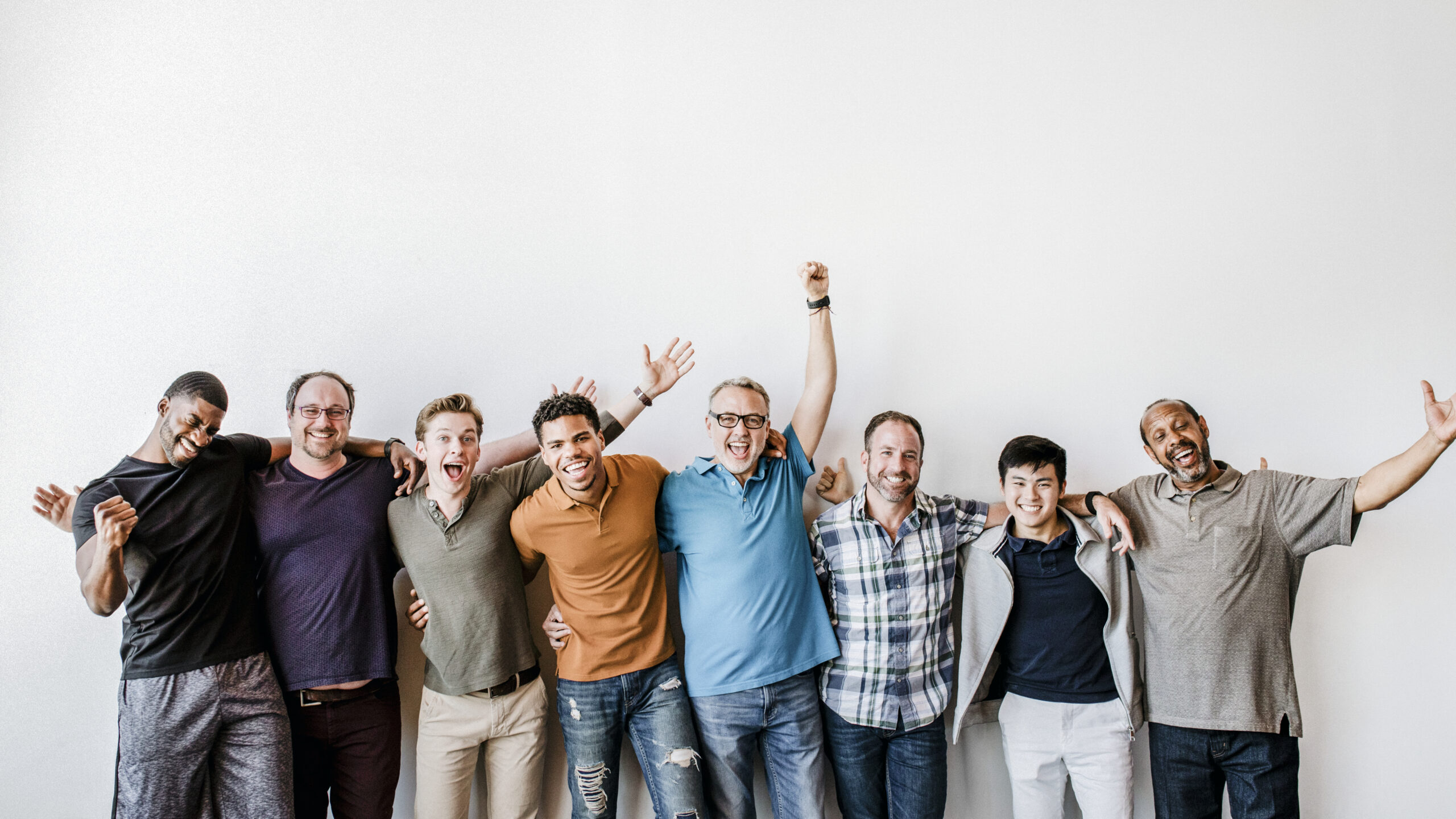 Men standing by a white wallpaper